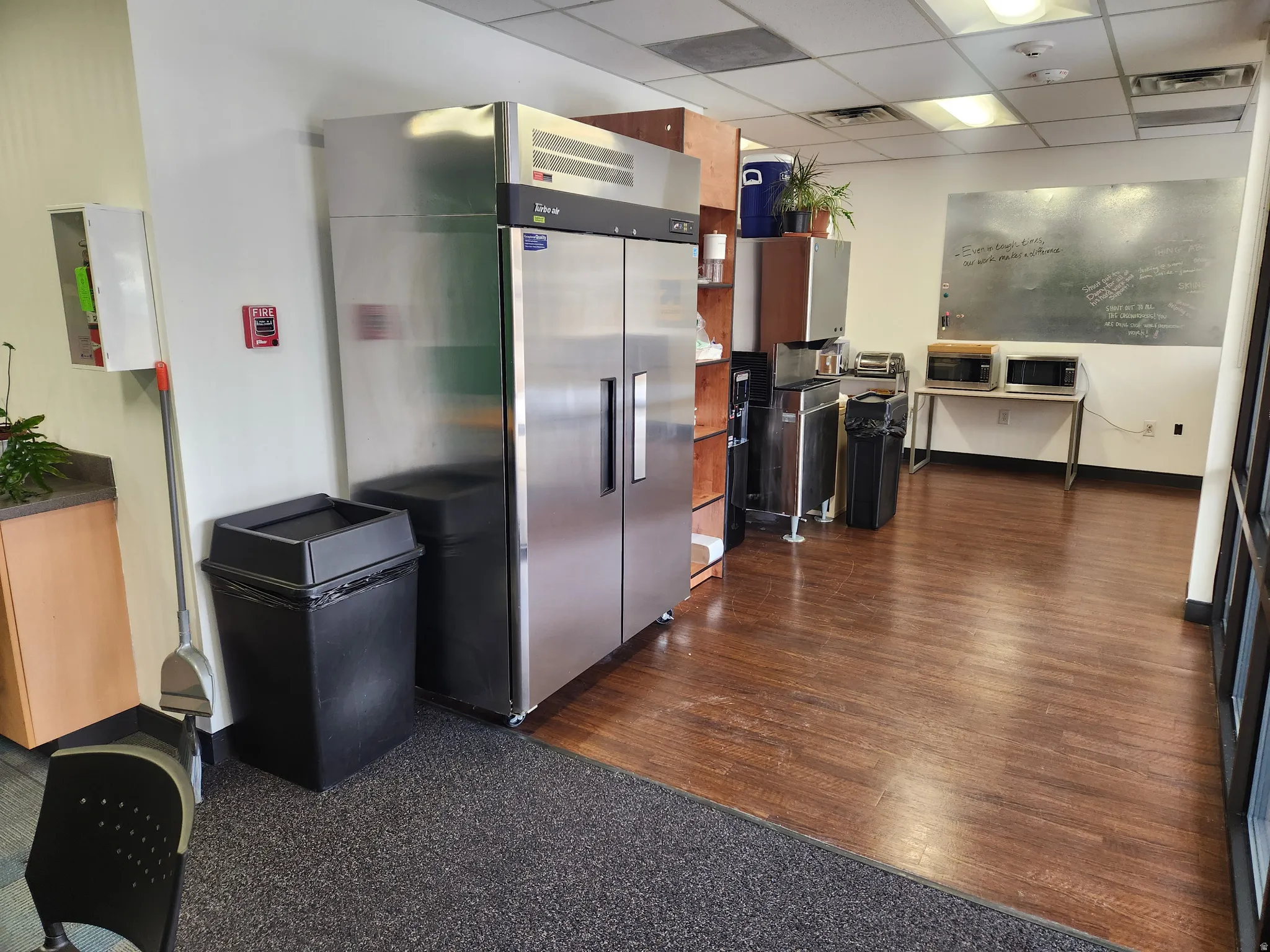 Kitchen featuring stainless steel appliances, a paneled ceiling, and dark countertops