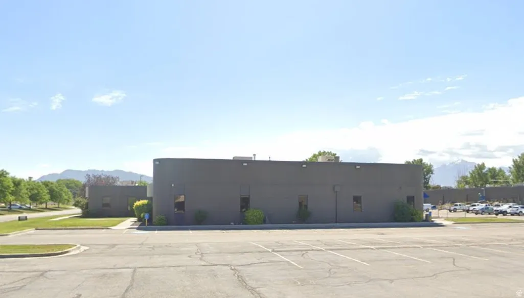 View of building exterior with uncovered parking and a mountain view