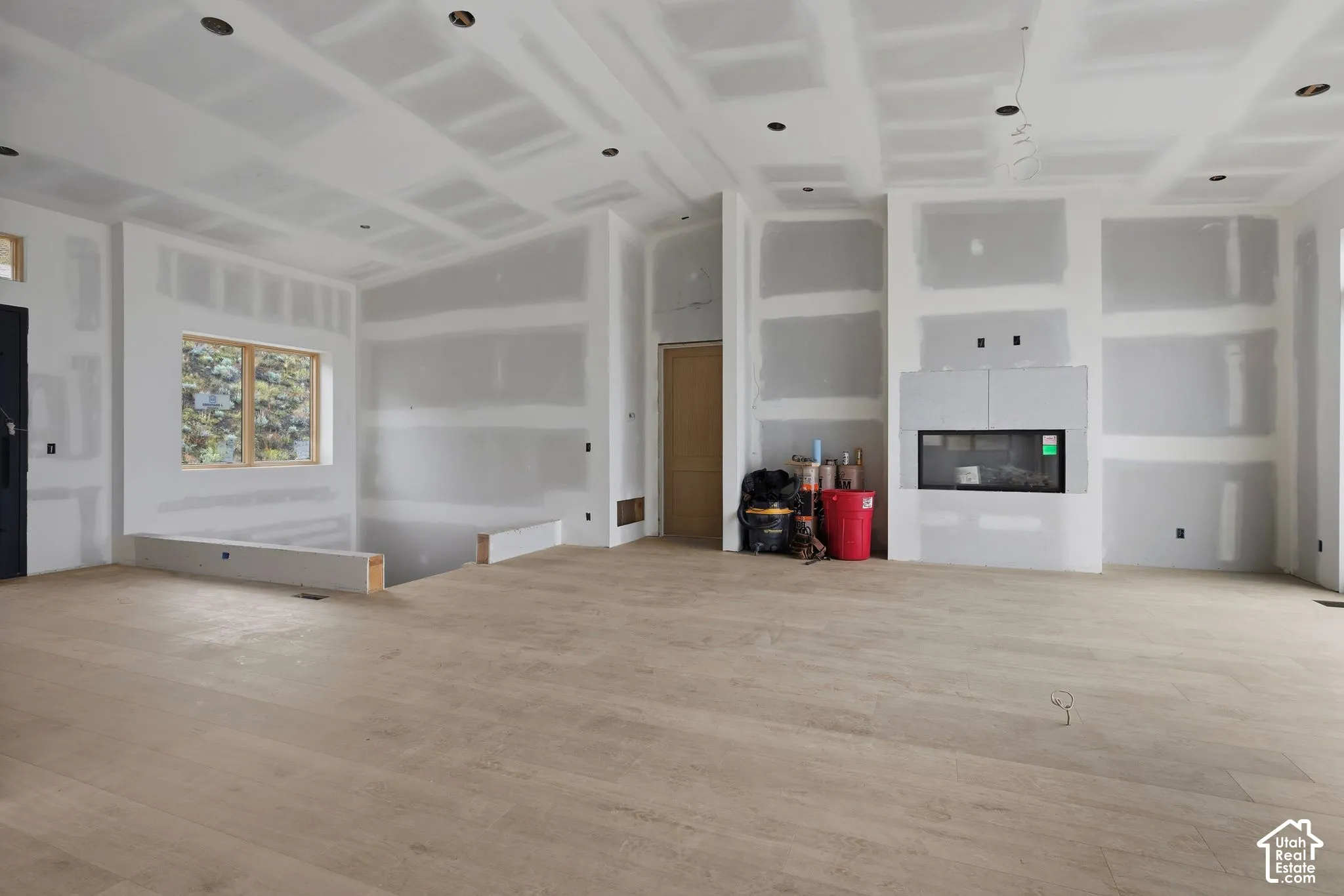 Open-concept interior featuring wood-finish flooring, recessed lighting, and a linear built-in fireplace
