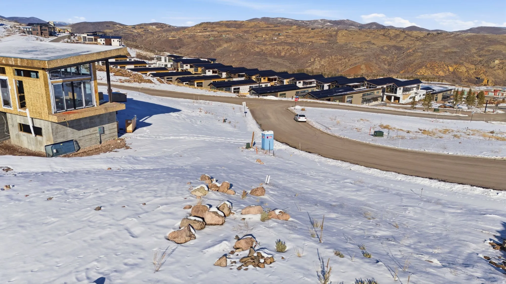 Snowy aerial view featuring a mountain view and a residential view