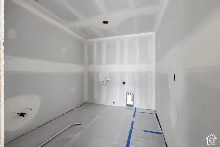 Unfinished room featuring drywall walls and ceiling, installed plumbing rough-ins, electrical outlet boxes, and recessed ceiling lighting