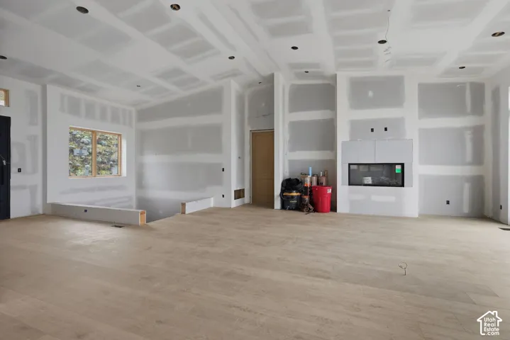 Open-concept interior featuring wood-finish flooring, recessed lighting, and a linear built-in fireplace