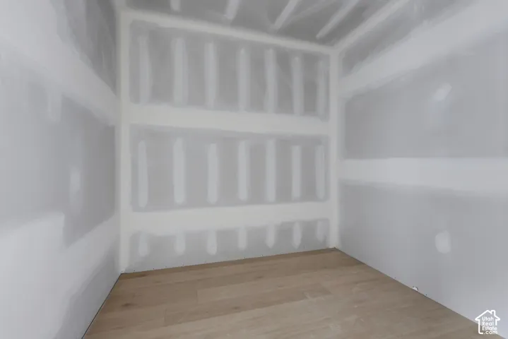 Unfinished interior space featuring drywall with taped seams and light-toned wood-finish flooring