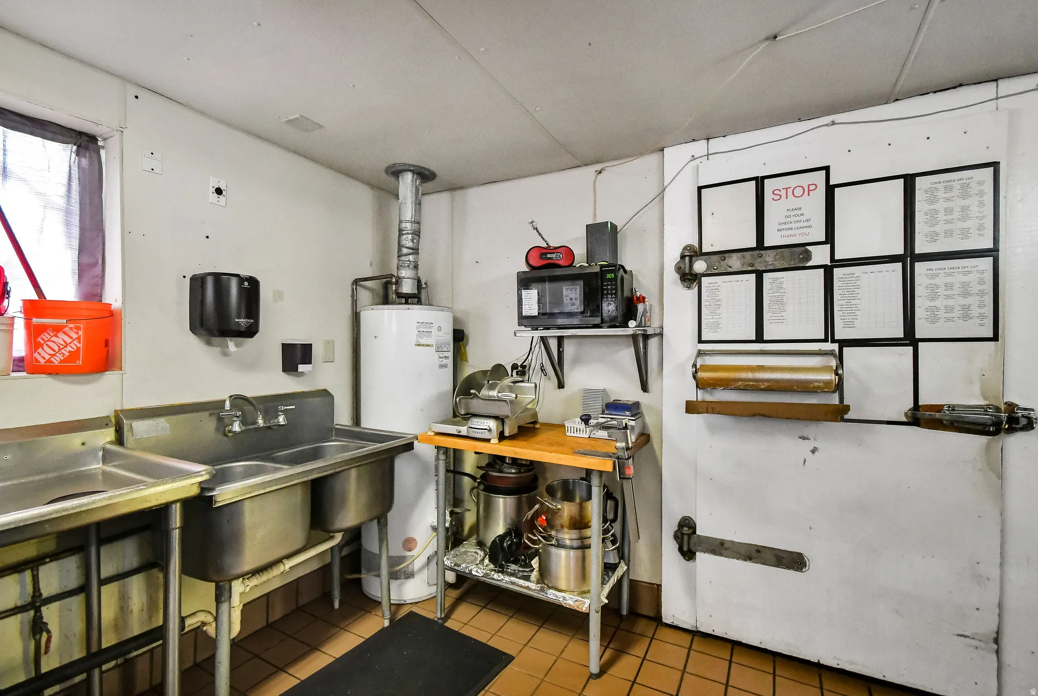 Kitchen featuring water heater and a sink