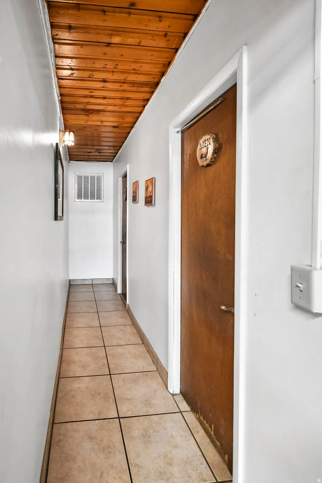 Corridor with wood ceiling and light tile patterned floors