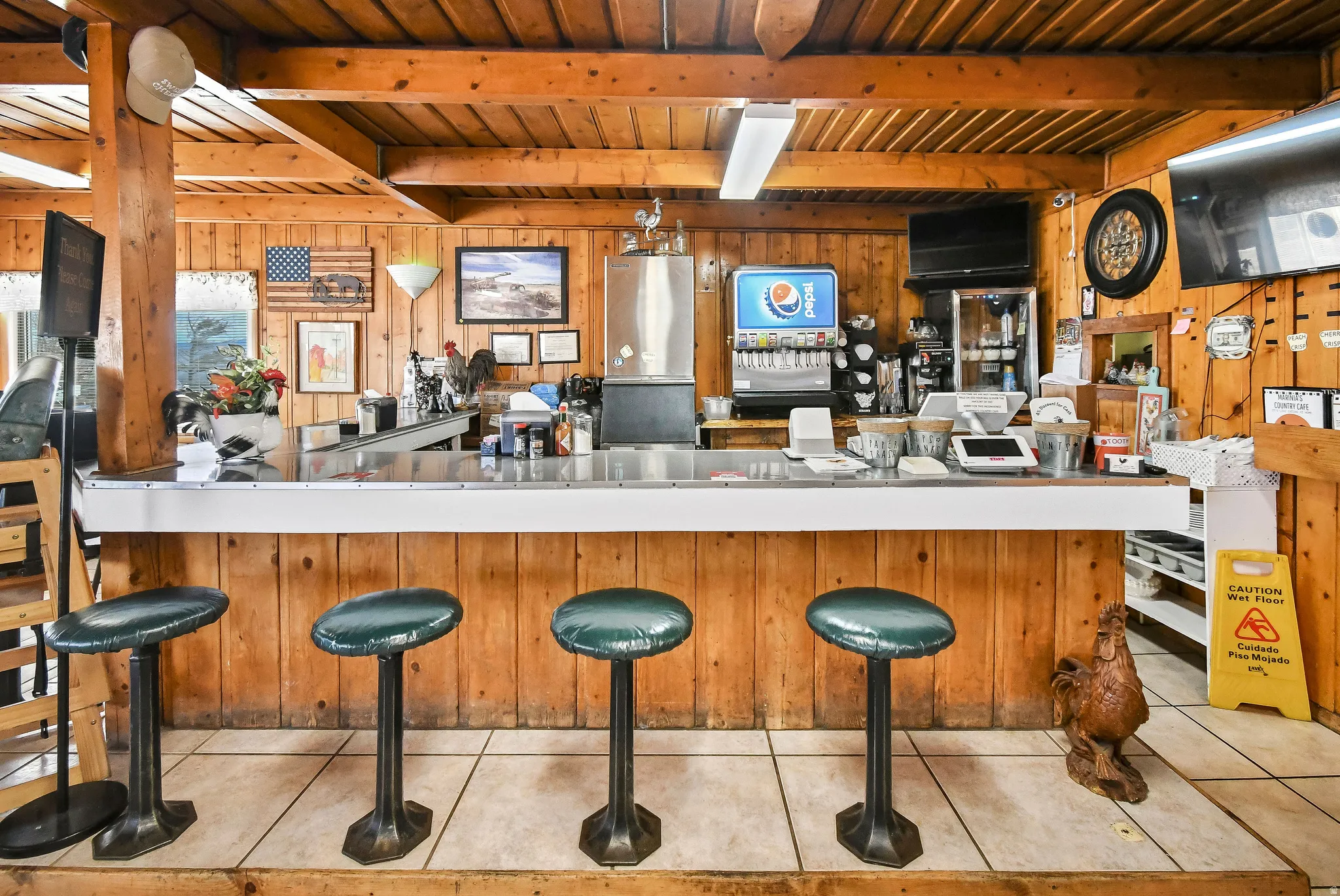 Bar area featuring wood walls, a wooden ceiling with exposed beams, decorative light fixtures, and light countertops