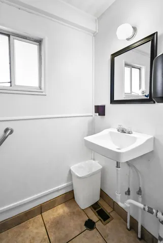 Half bath with tile patterned floors and a sink