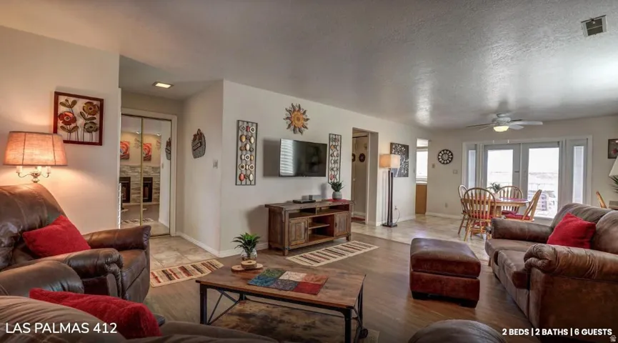 Living area featuring a textured ceiling, a ceiling fan, and wood finished floors