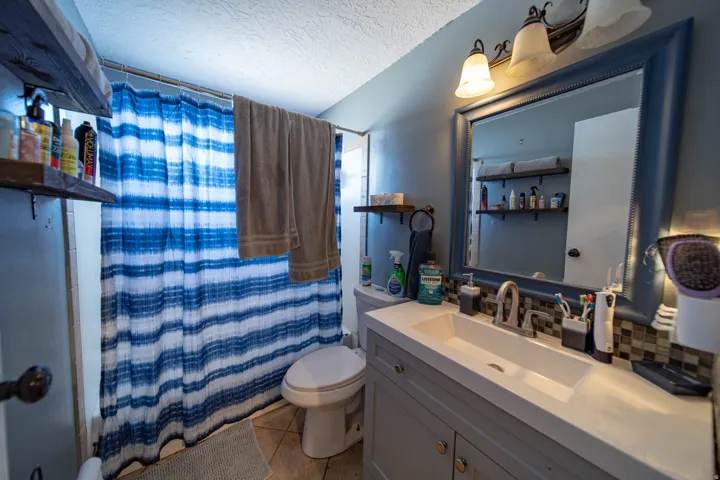 Bathroom with vanity, a textured ceiling, and light tile patterned floors