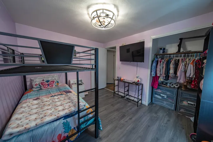 Bedroom with dark wood-style flooring, a closet, and a chandelier
