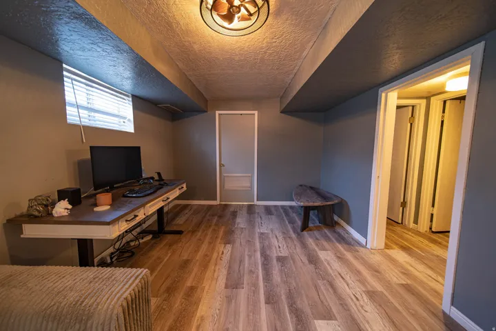 Office area featuring light wood-style floors and a textured ceiling
