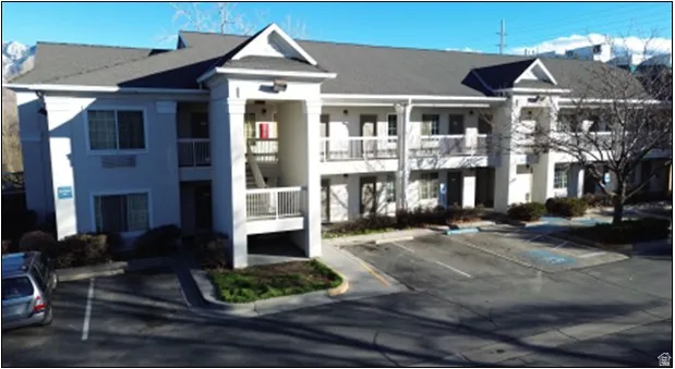 View of apartment building / complex with uncovered parking