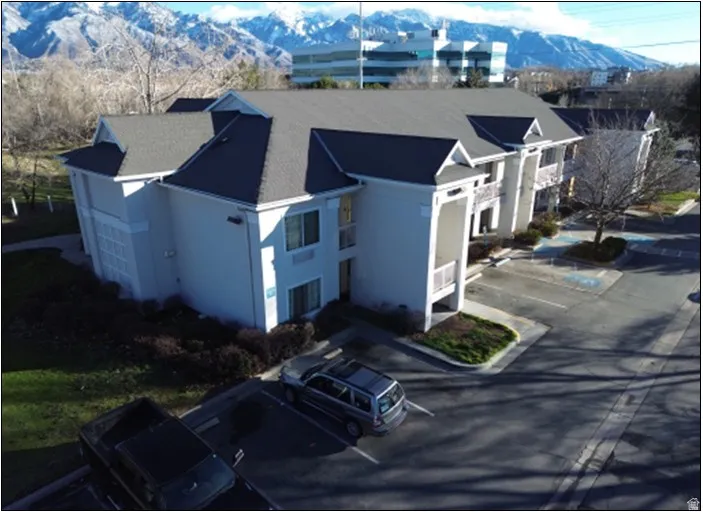 View of front of home with a mountain view, uncovered parking, and stucco siding