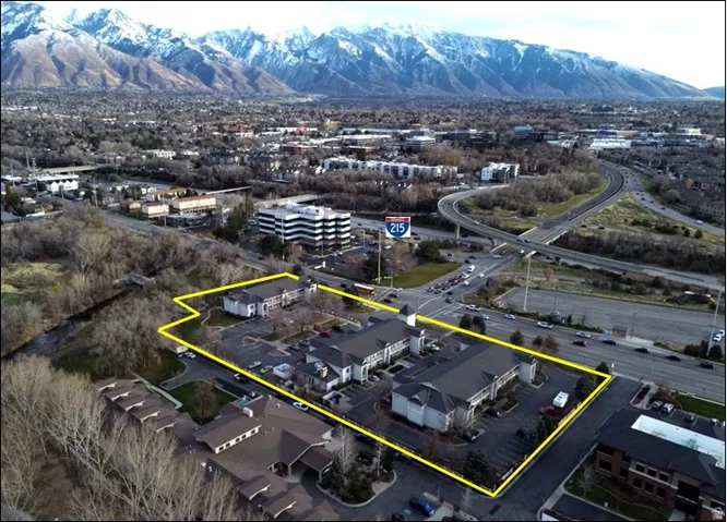 Aerial view of property and surrounding area featuring a mountainous background and property parcel outlined