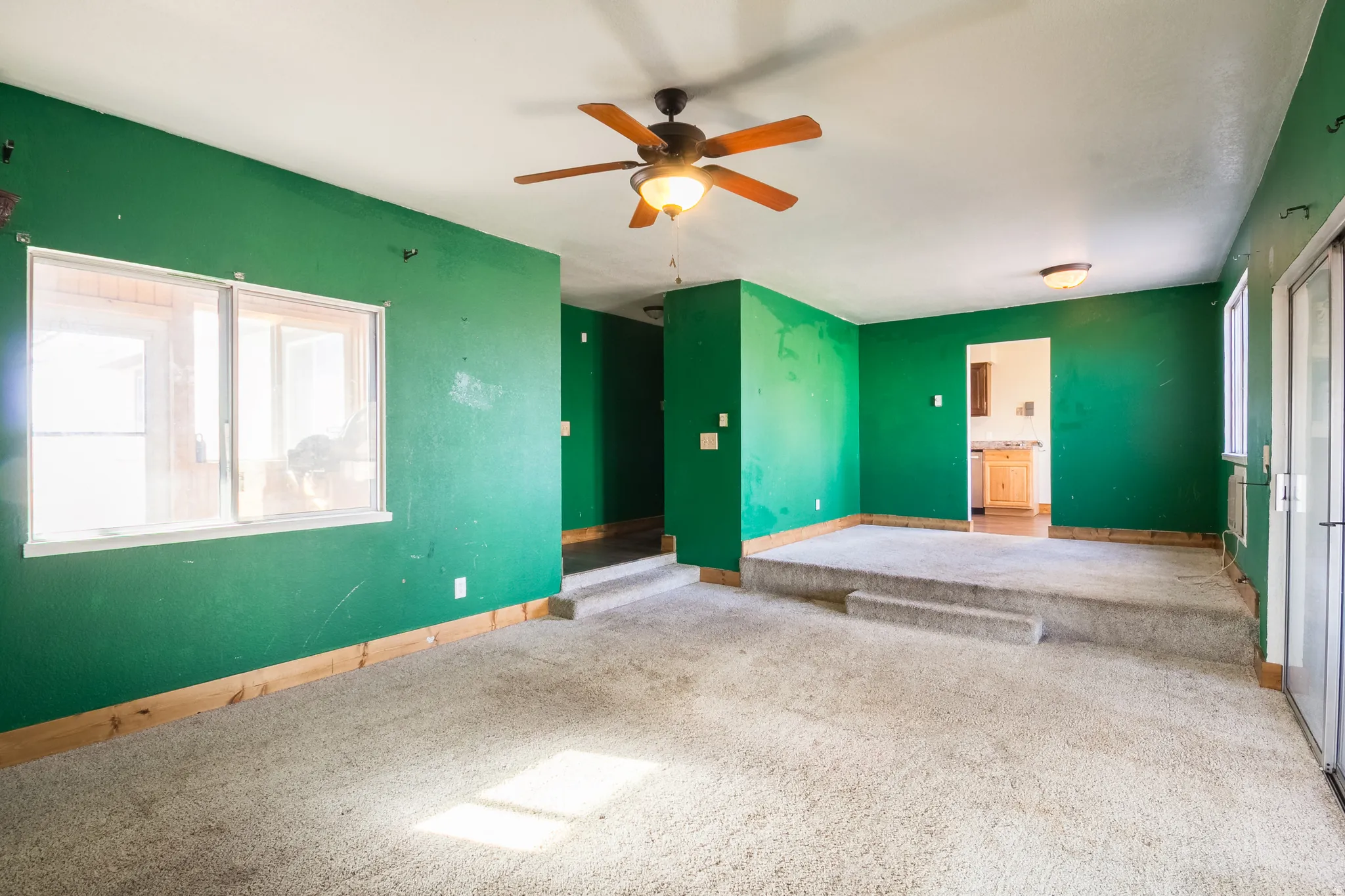 Unfurnished room with plenty of natural light, carpet flooring, and a ceiling fan