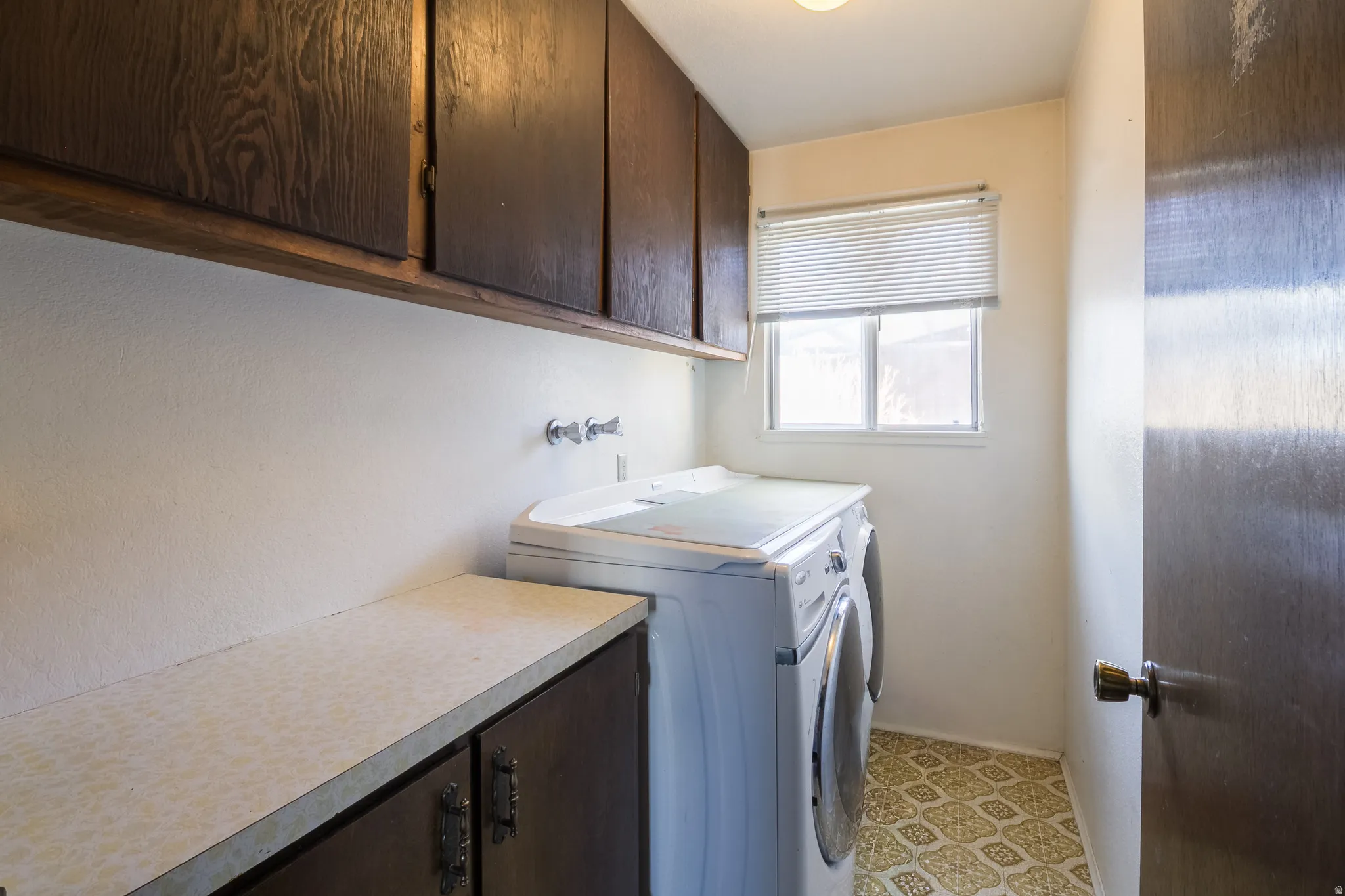 Laundry area featuring cabinet space, separate washer and dryer, and light floors