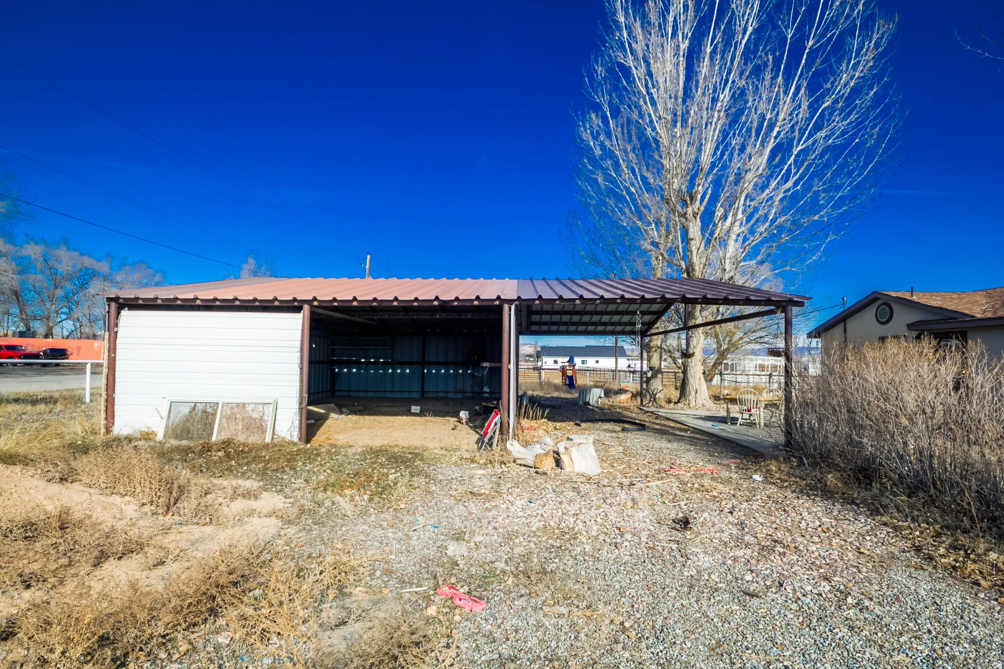 Back of house with an outbuilding, an outdoor structure, and a metal roof