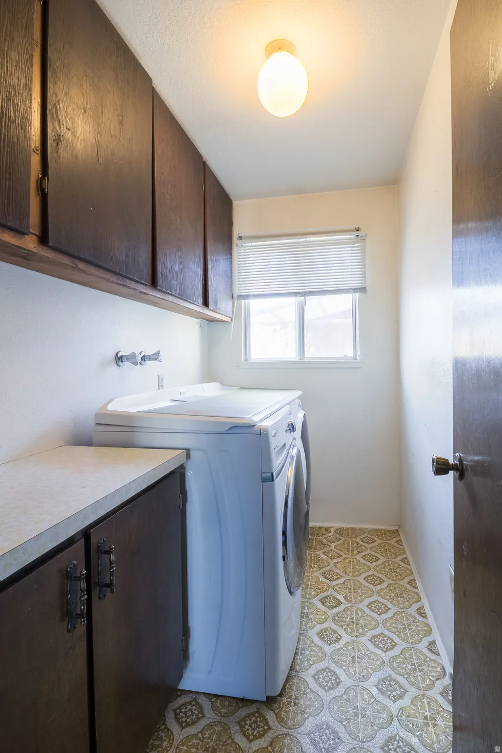 Washroom with cabinet space and washing machine and clothes dryer