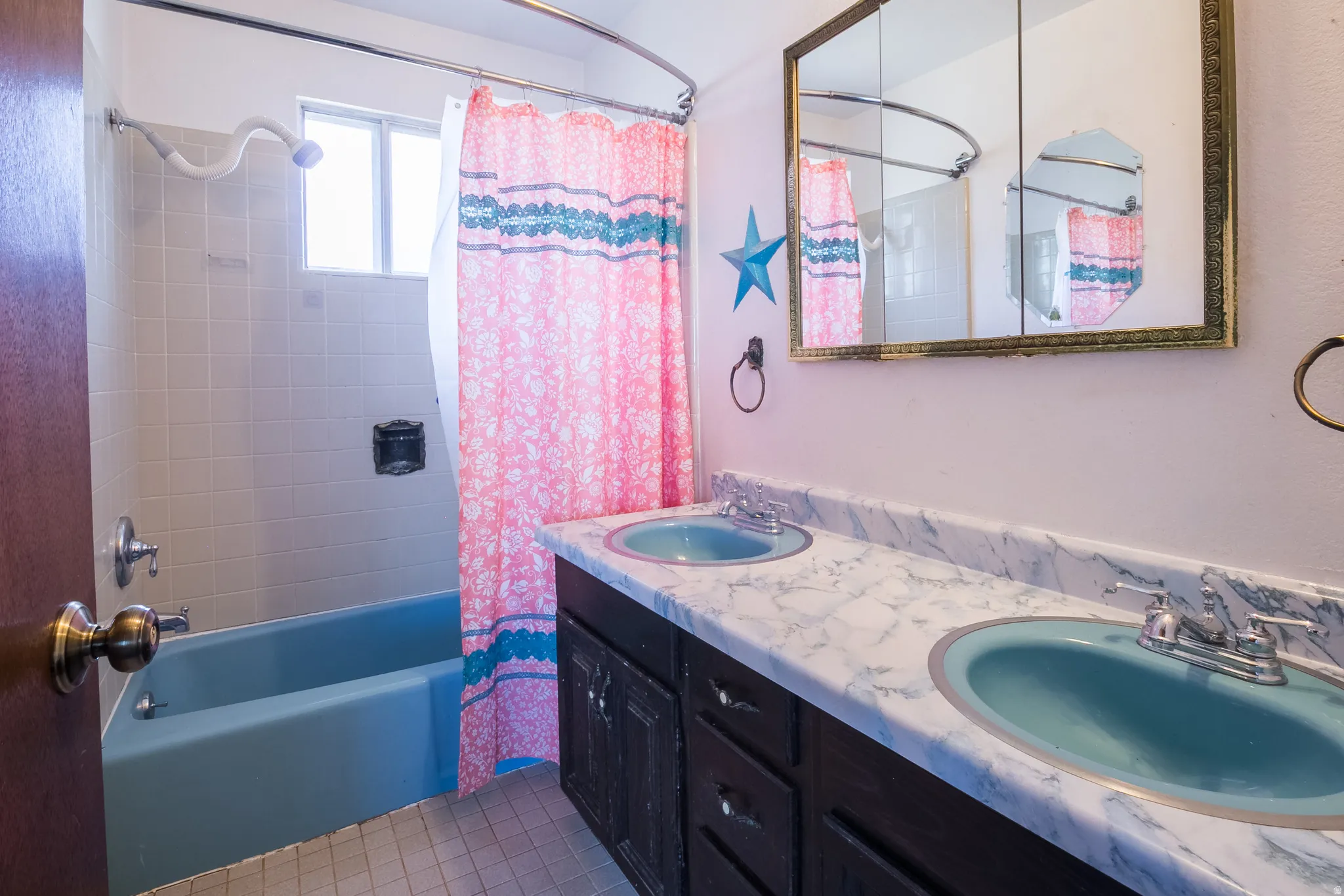 Full bathroom featuring shower / tub combo, double vanity, and light tile patterned flooring
