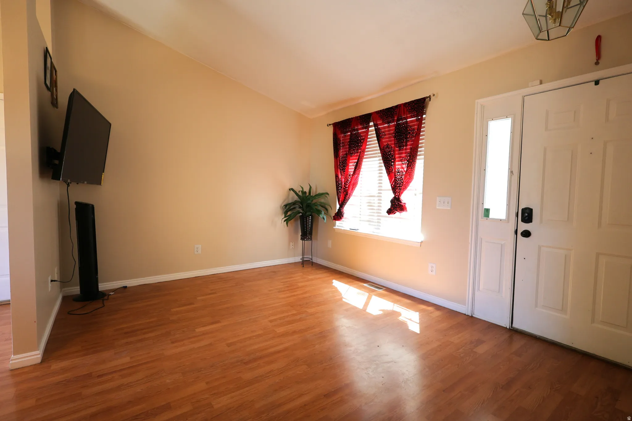 Entrance foyer with vaulted ceiling and wood finished floors