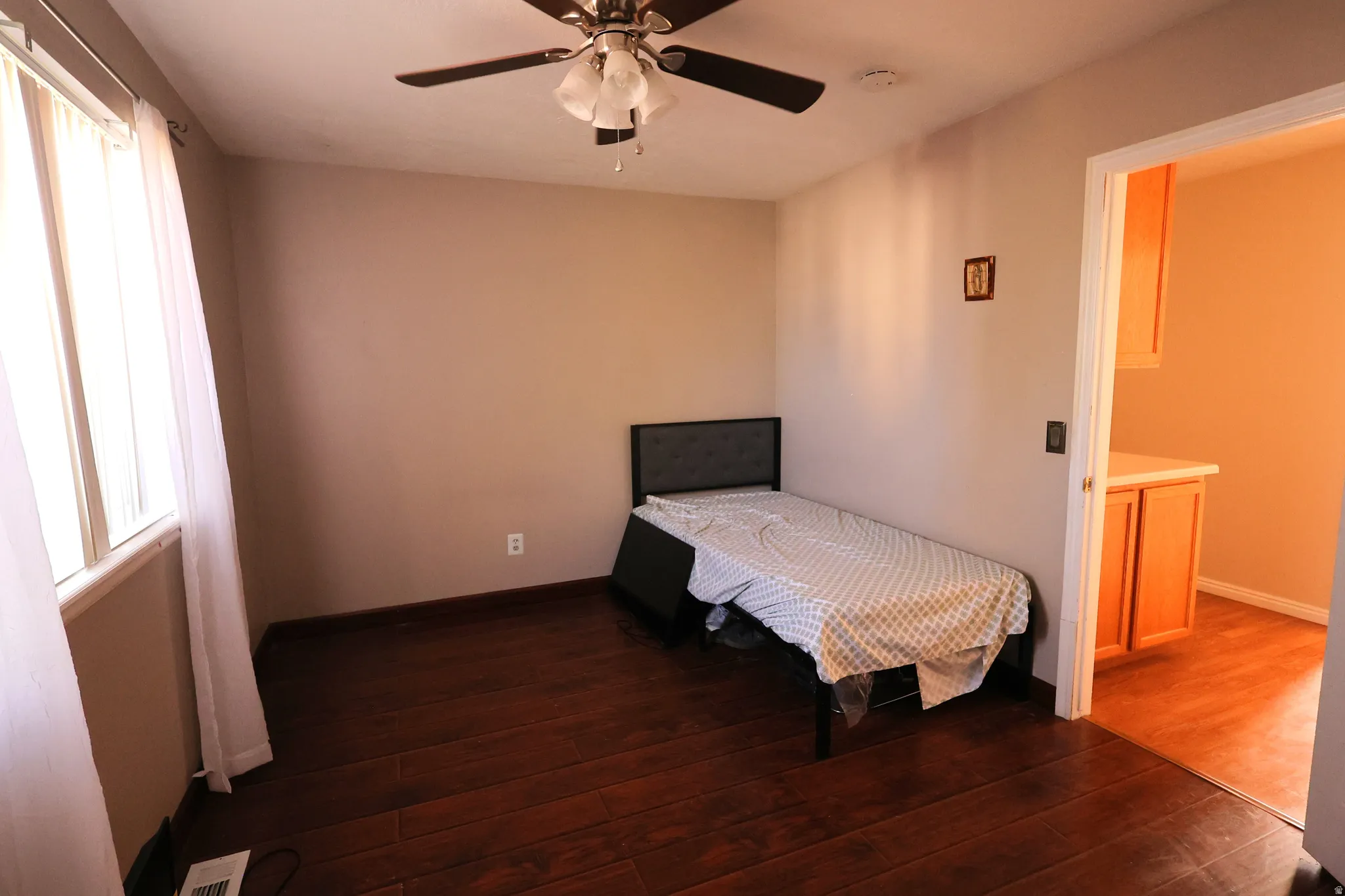 Bedroom with dark wood-style flooring and ceiling fan