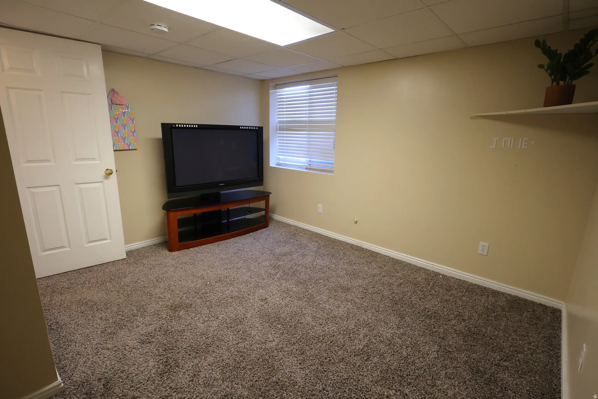 Basement featuring carpet floors and a paneled ceiling