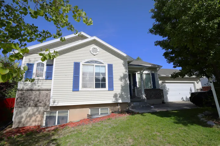 View of front of property featuring a front lawn and an attached garage