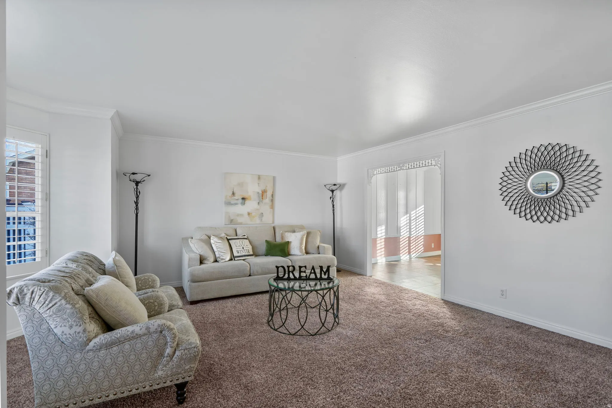 Carpeted living room with crown molding and baseboards