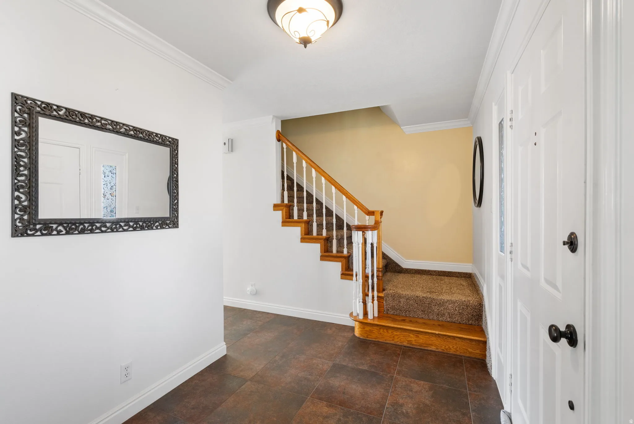 Staircase with baseboards and crown molding
