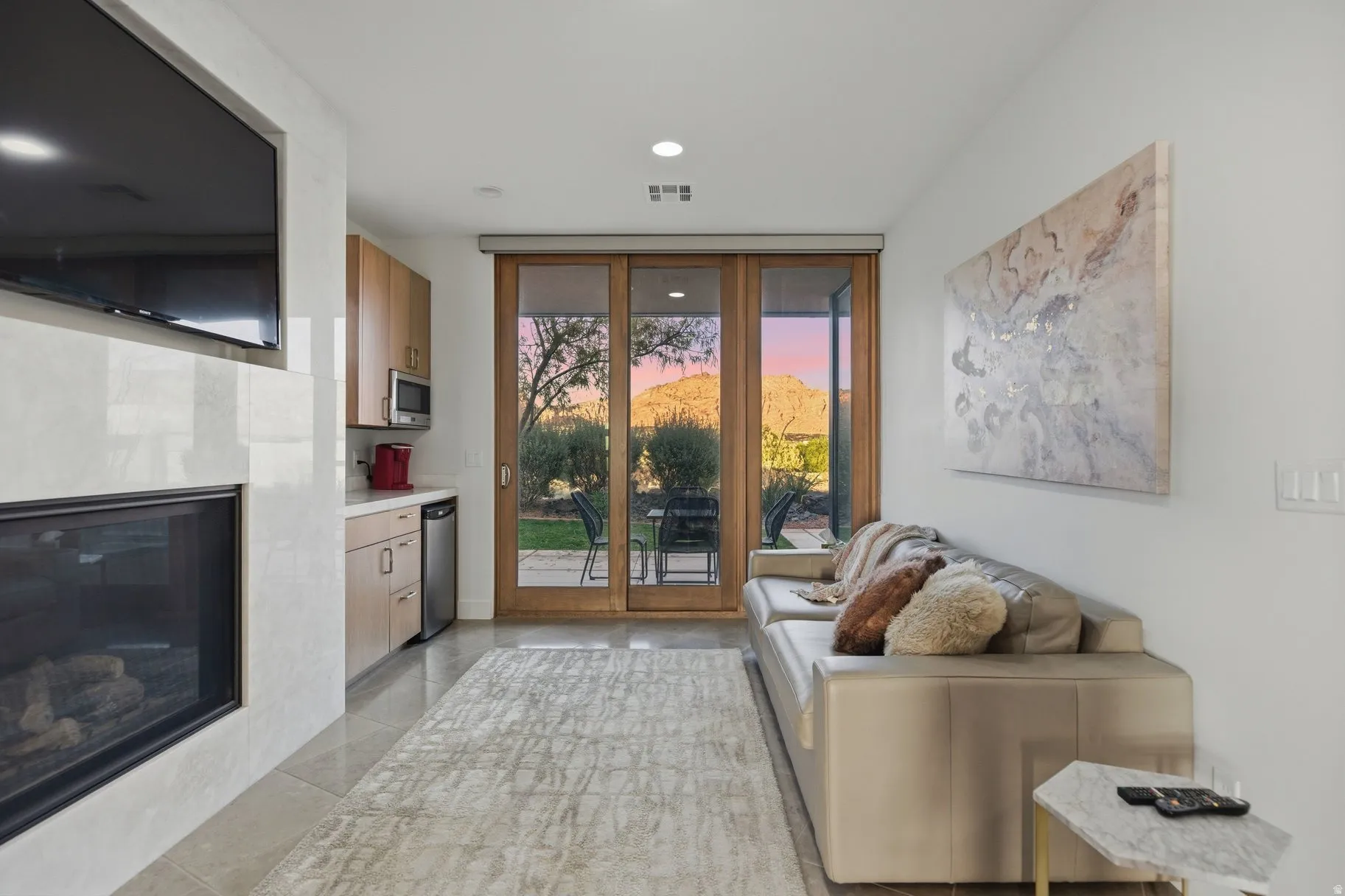 Living area featuring a tile fireplace, floor to ceiling windows, and light tile patterned flooring