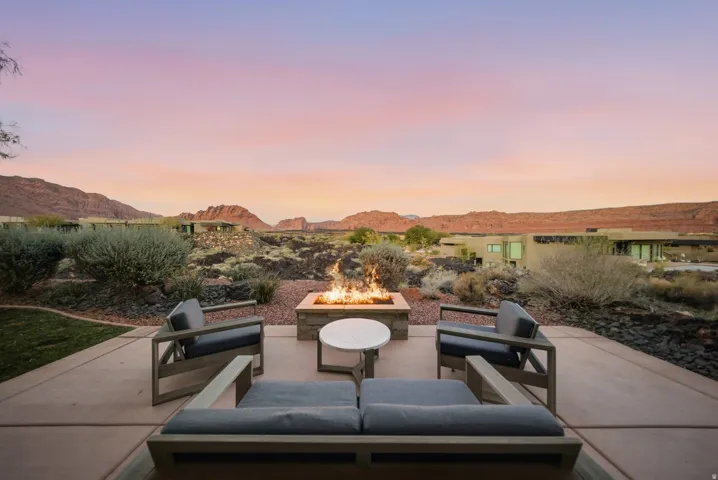 Patio terrace at dusk featuring a patio area, an outdoor fire pit, and a mountain view