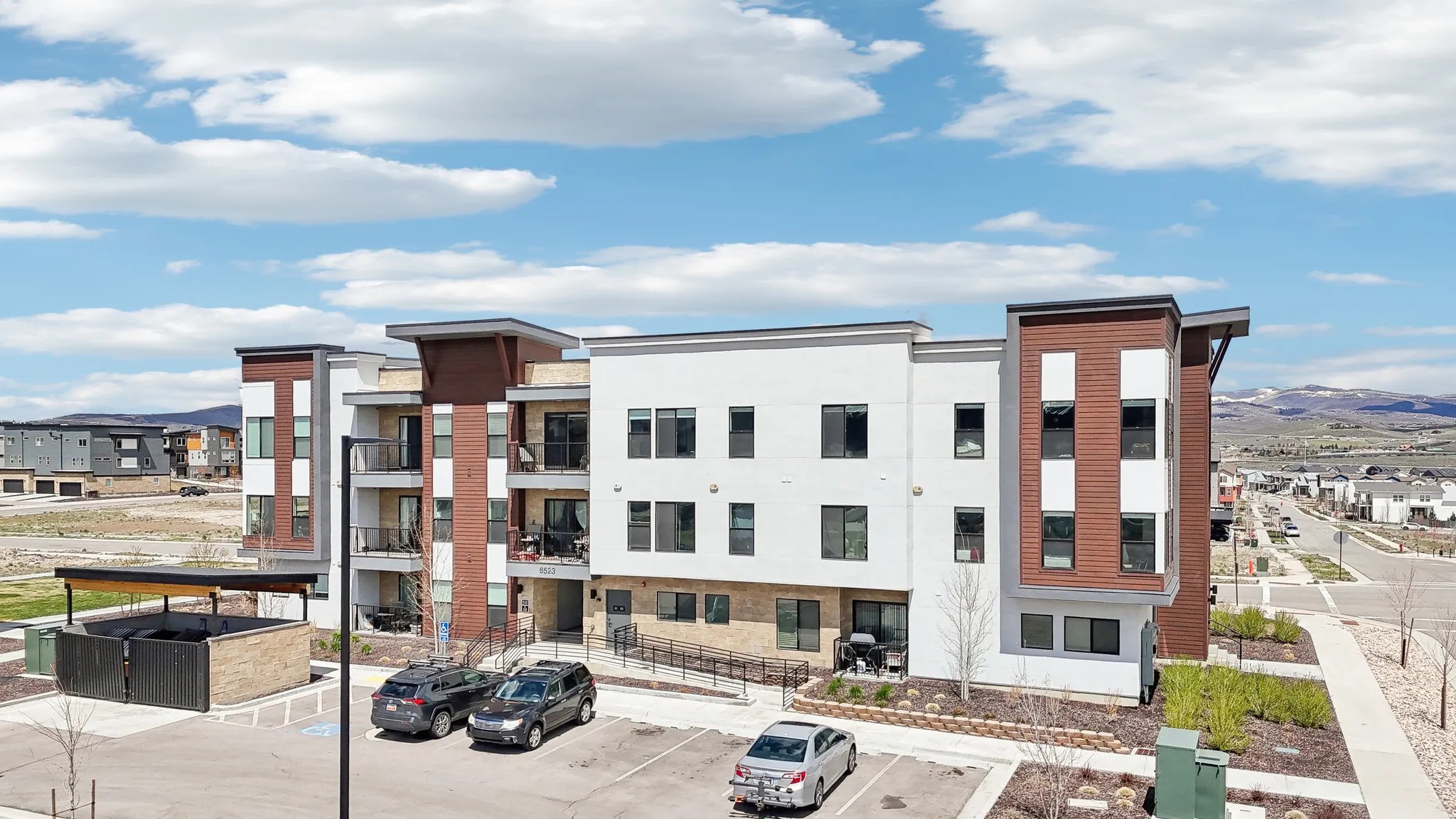 View of property with a mountain view and uncovered parking