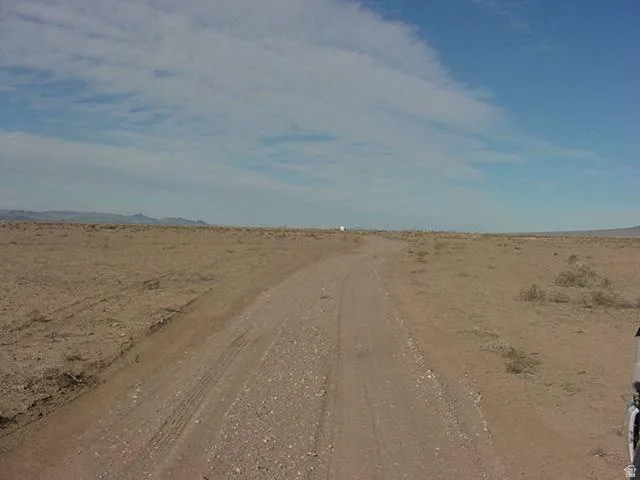 View of dirt / gravel road featuring a view of rural / pastoral area