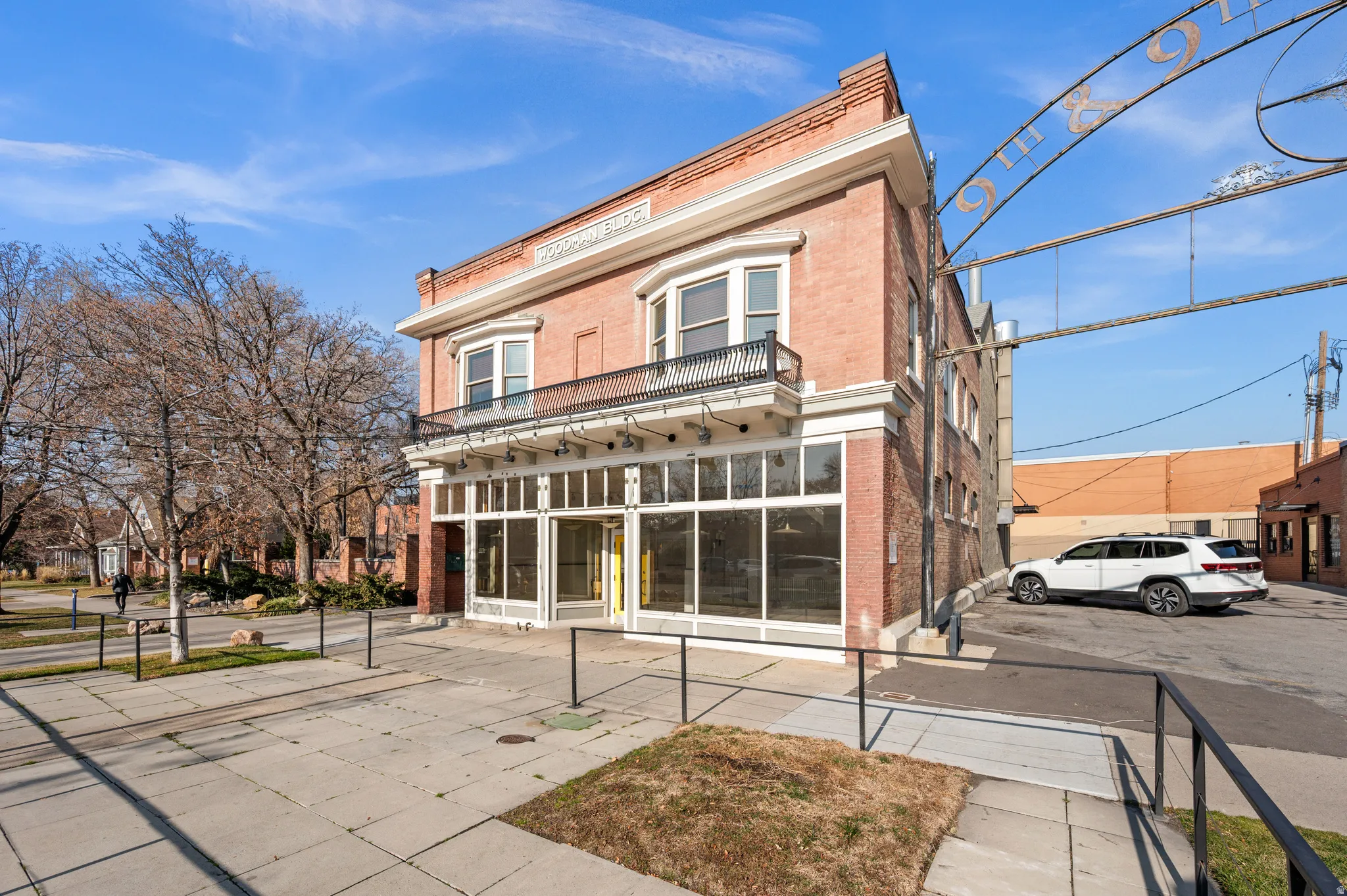 Back of property featuring brick siding, a balcony, and a sunroom