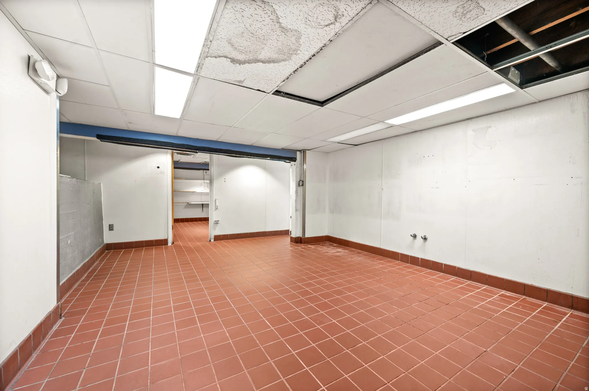 Finished below grade area featuring a paneled ceiling and baseboards