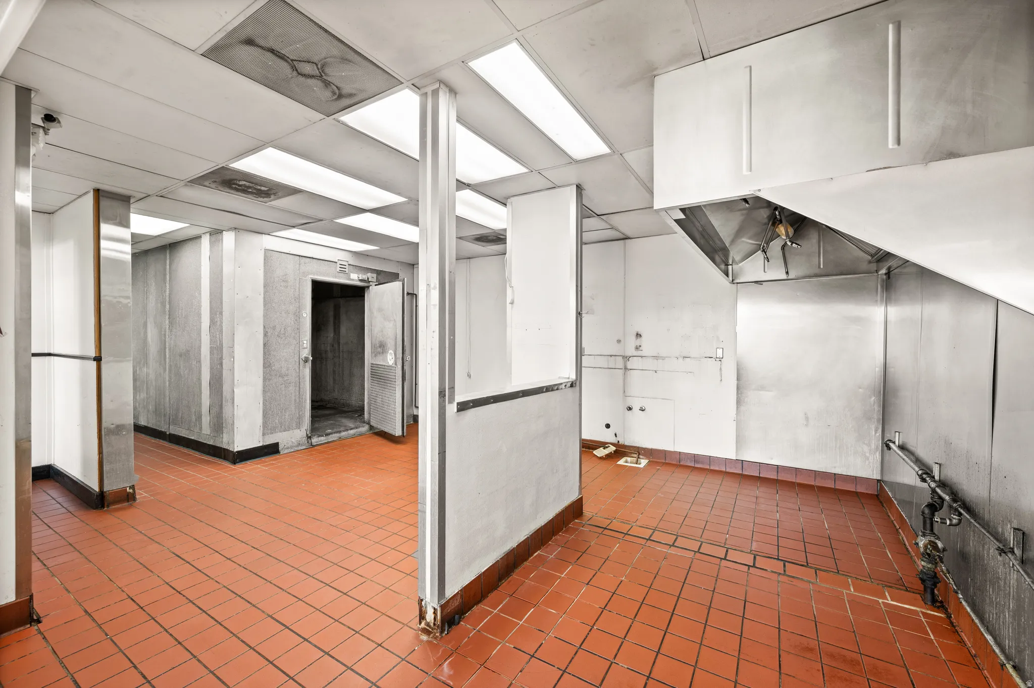 Basement with a paneled ceiling and baseboards