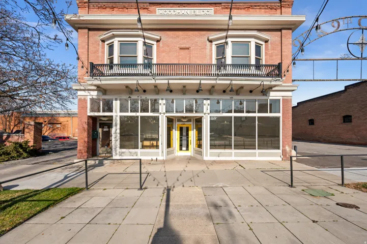 Rear view of property with brick siding, a balcony, and a sunroom