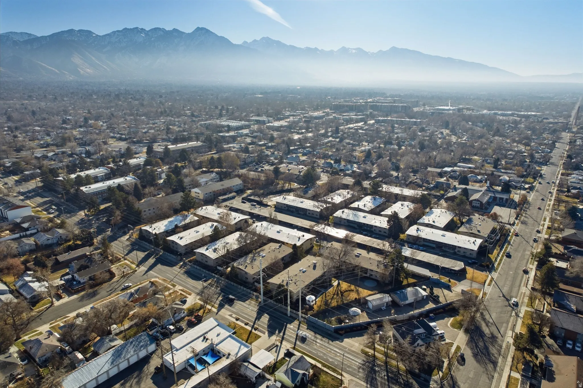 Aerial view of property and surrounding area with a mountain backdrop