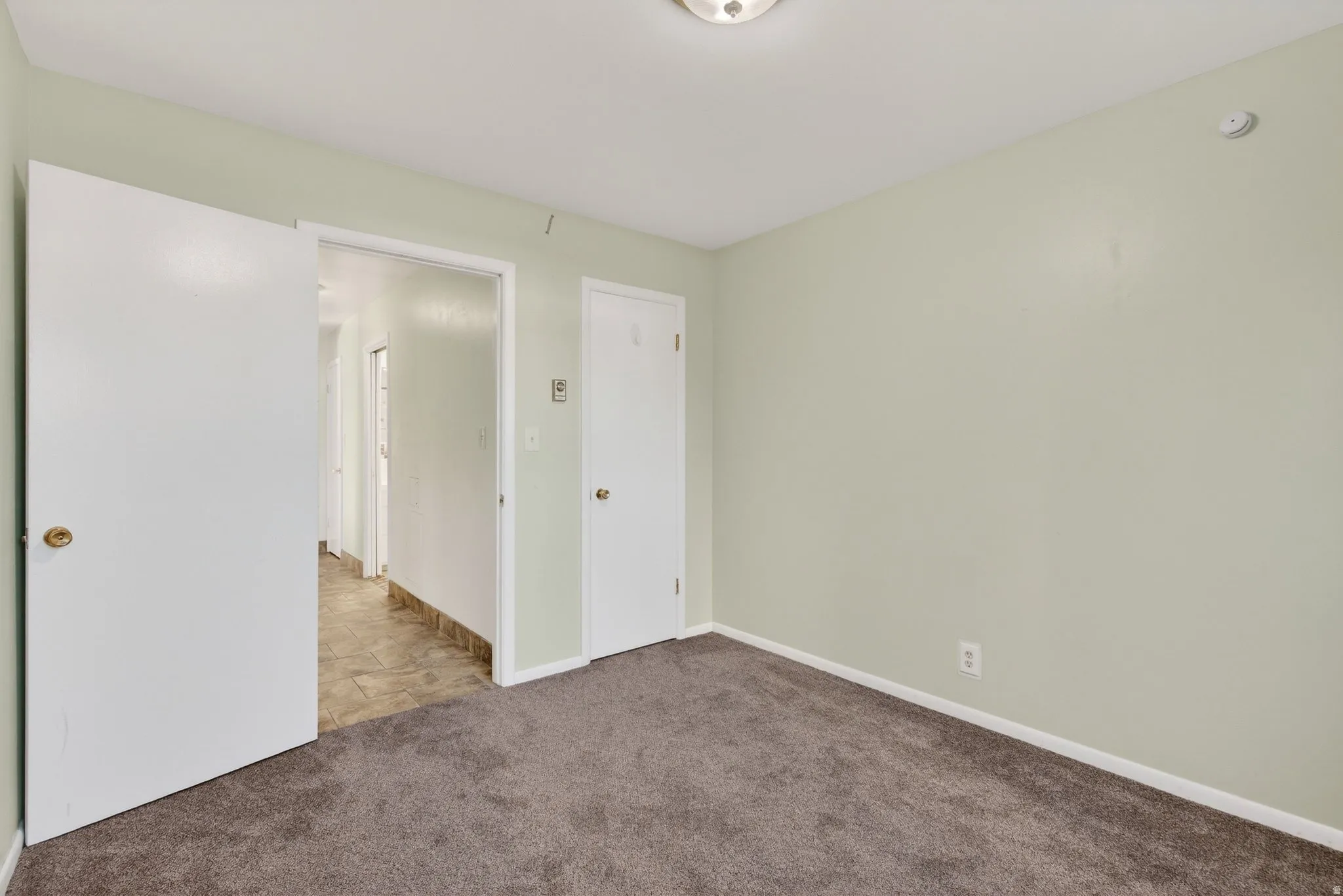 Unfurnished bedroom with carpet floors and baseboards