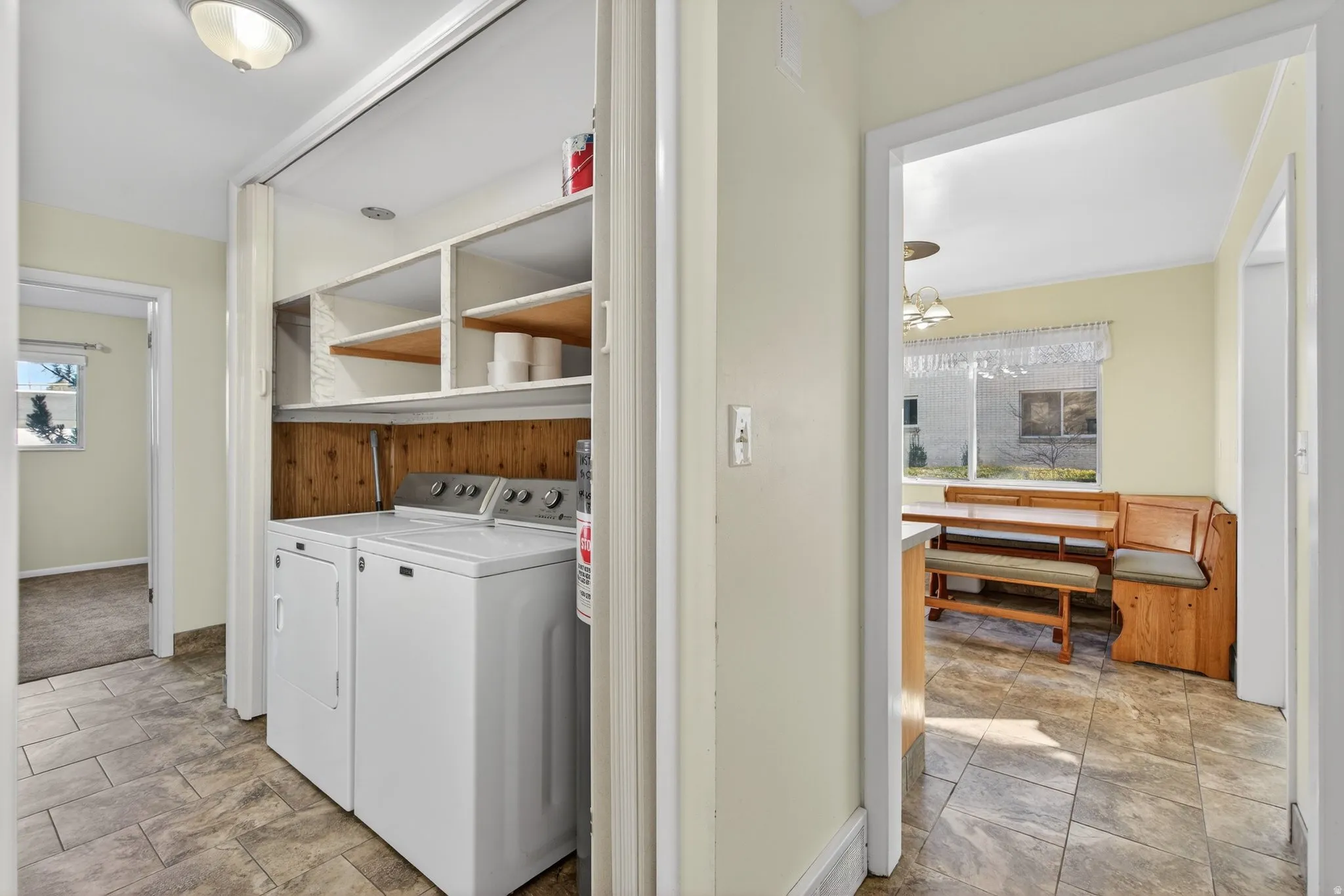 washer and dryer with view of kitchen and stone finish floors