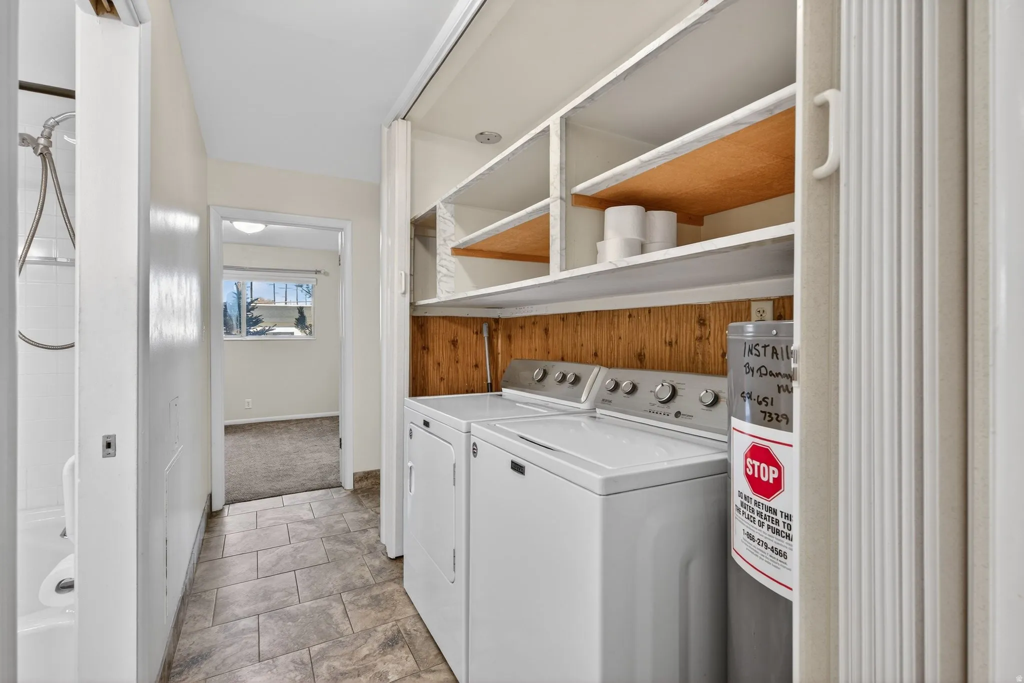 Laundry room featuring washing machine and dryer and water heater