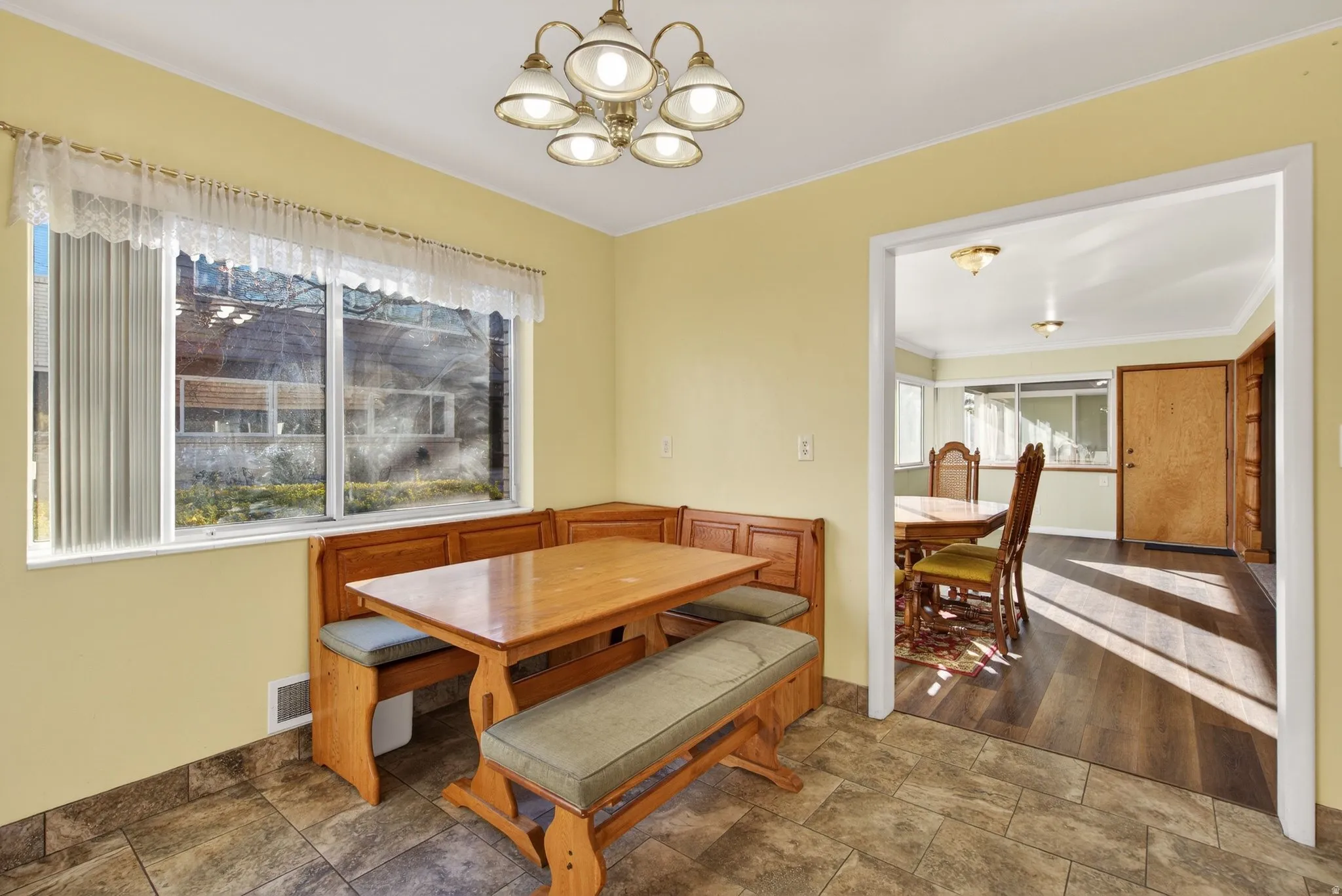 Dining area with stone finish floors, plenty of natural light, a chandelier, and ornamental molding