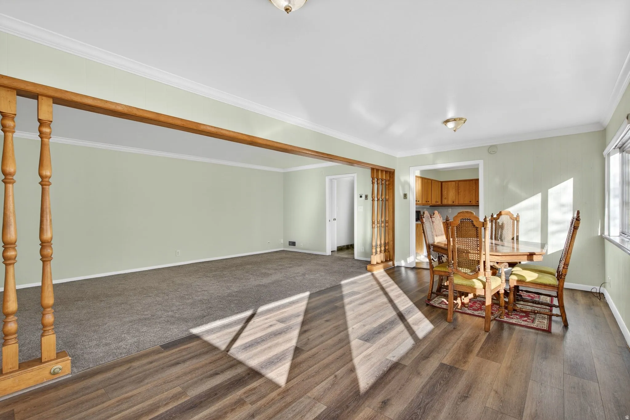 Dining area with ornamental molding and dark wood-style flooring