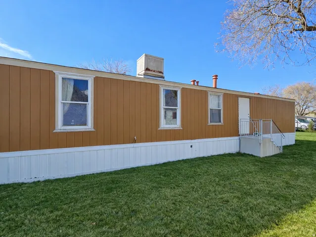 View of property exterior featuring a lawn and a central air condition unit