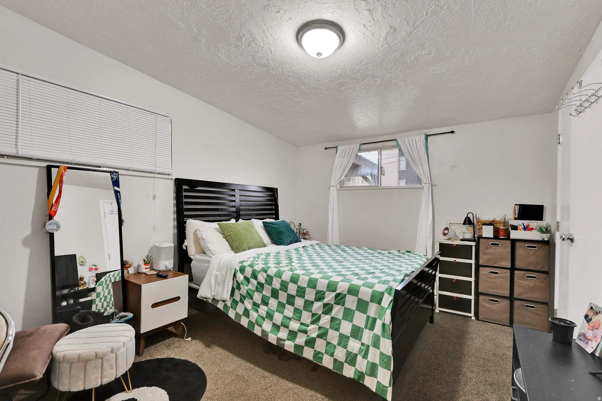Bedroom with a textured ceiling and dark colored carpet
