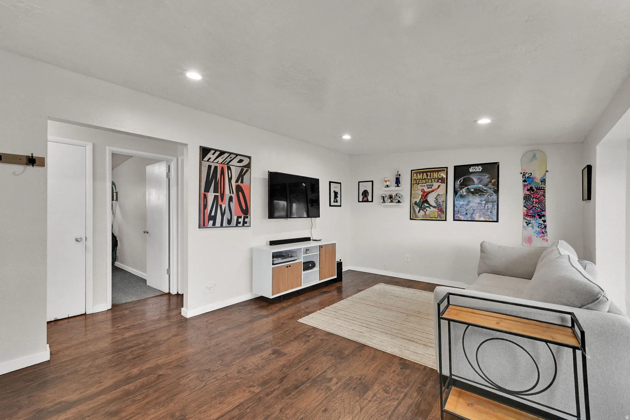 Living area featuring dark wood-type flooring and recessed lighting
