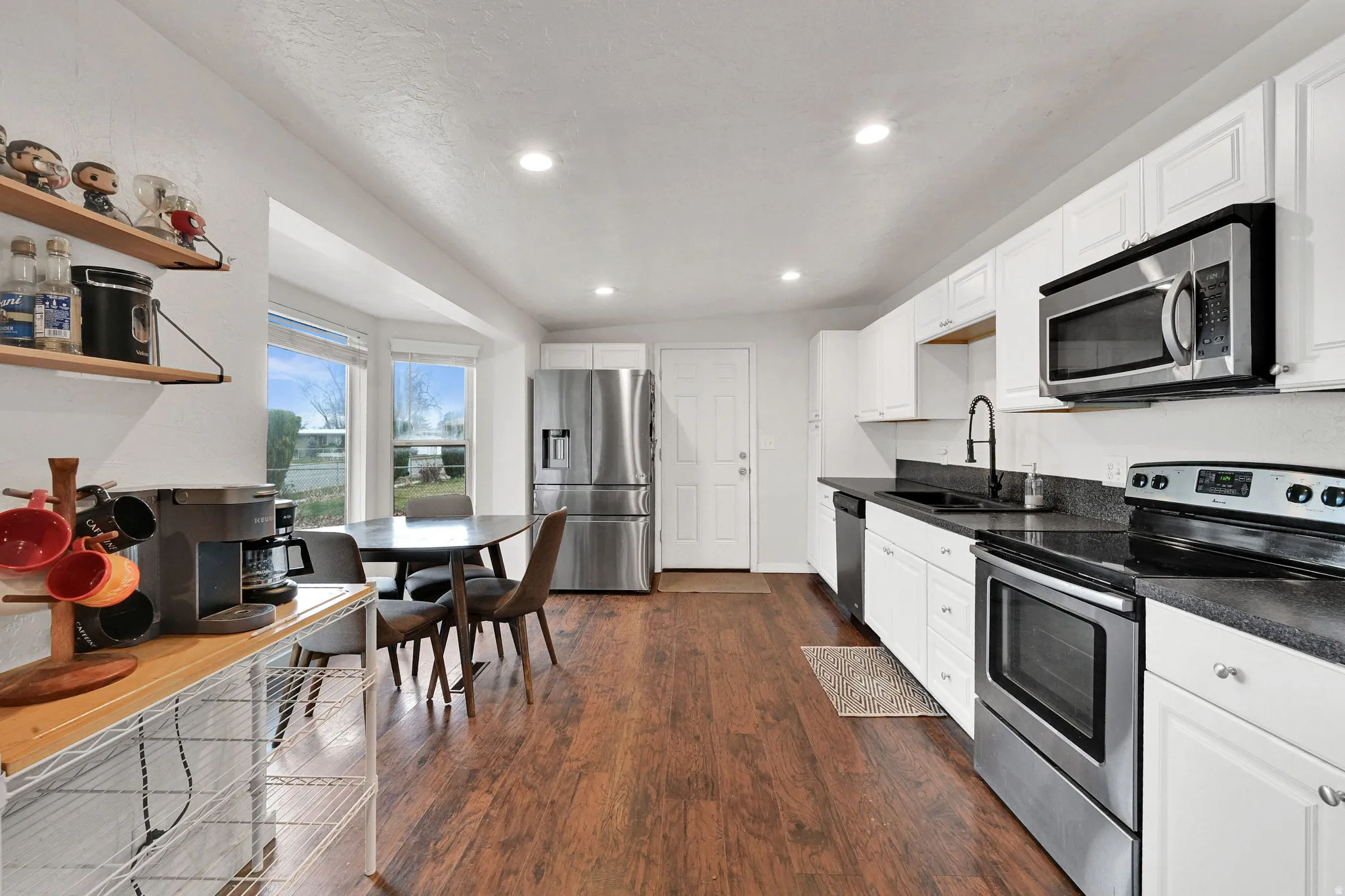 Kitchen featuring appliances with stainless steel finishes, white cabinets, dark wood-type flooring, recessed lighting, and open shelves