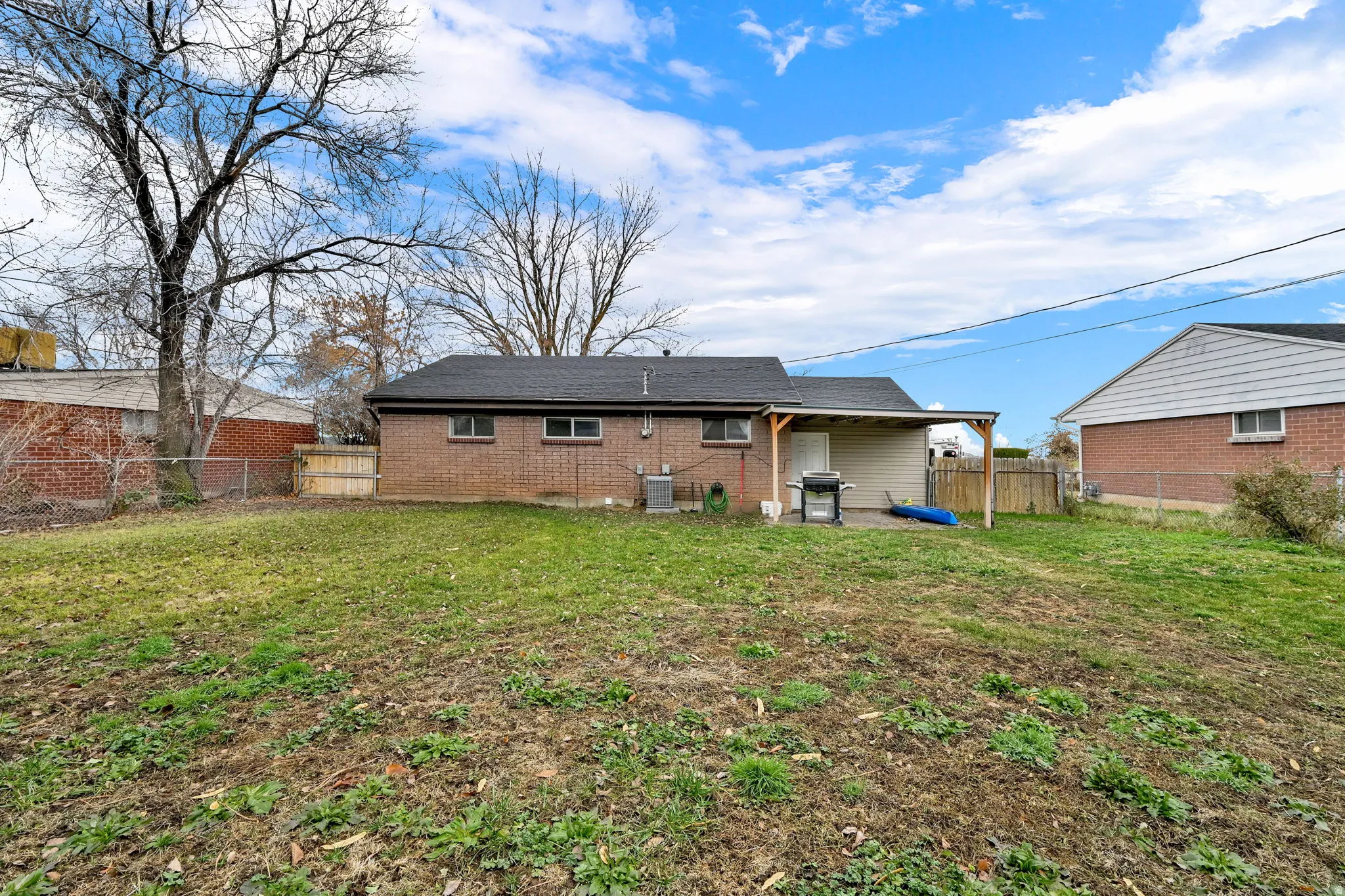 Back of house with a patio, a fenced backyard, and brick siding