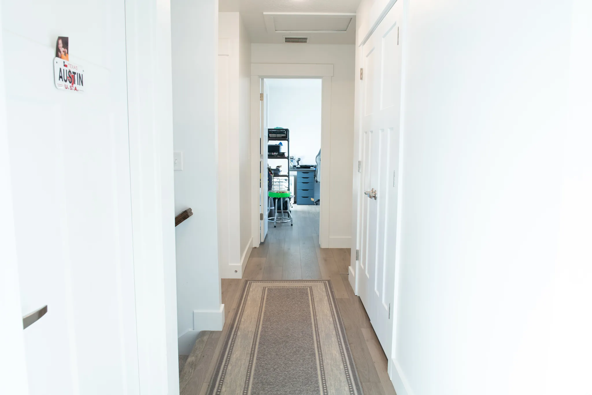 Hall with wood-style floors and attic access. View of the linen closet.