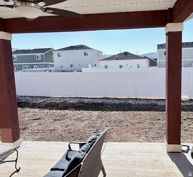 Fenced backyard featuring ceiling fan and a patio area